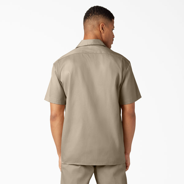 Man wearing a dickies dark sand short-sleeve shirt and dark sand dickies pants on a white background